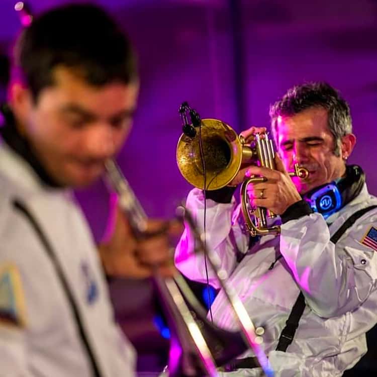 Concerti Silent $ Live Band Posaunisten in Astronautenanzügen spielen mit Kopfhörern