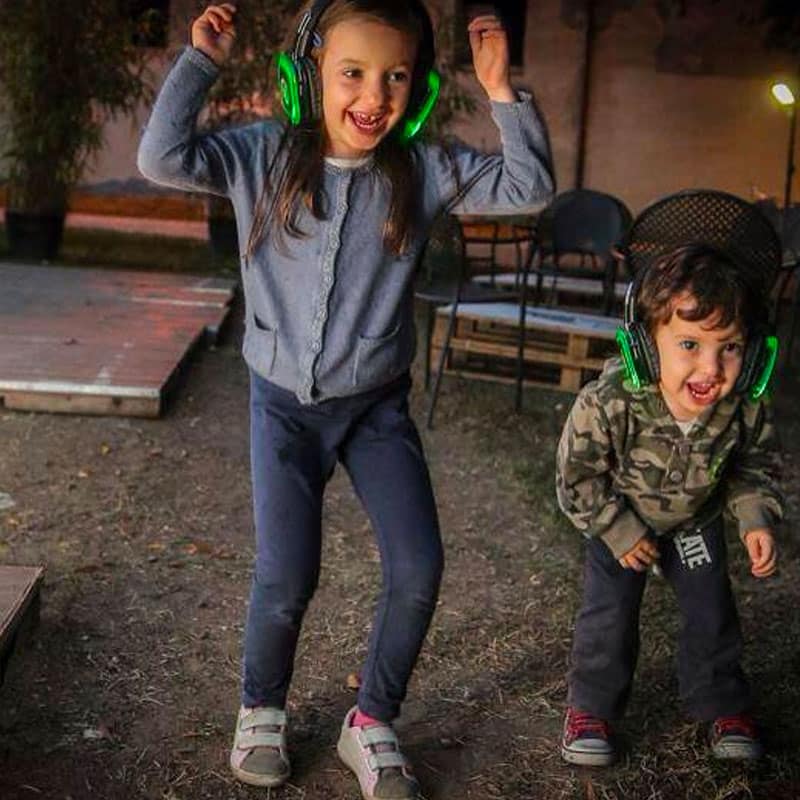 babydance Kinder tanzen mit grünen kabellosen Kopfhörern auf einer Party