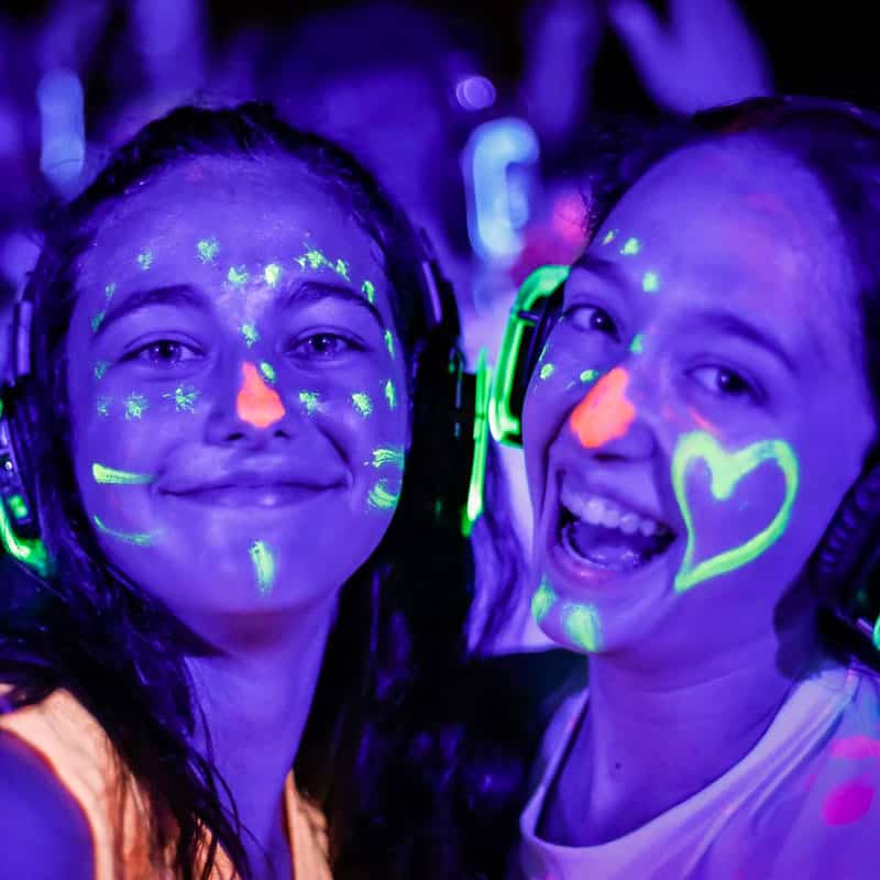 feste-silent-per-bambini Mädchen mit Neon-Make-up und Silent-Disco-Kopfhörern