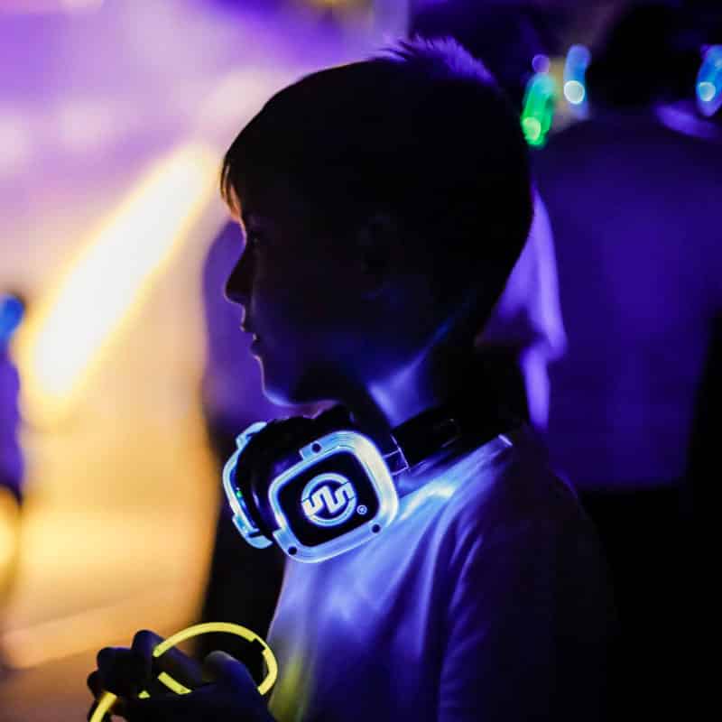 festebambini Kind mit LED-Kopfhörern auf einer Silent Party für Kinder