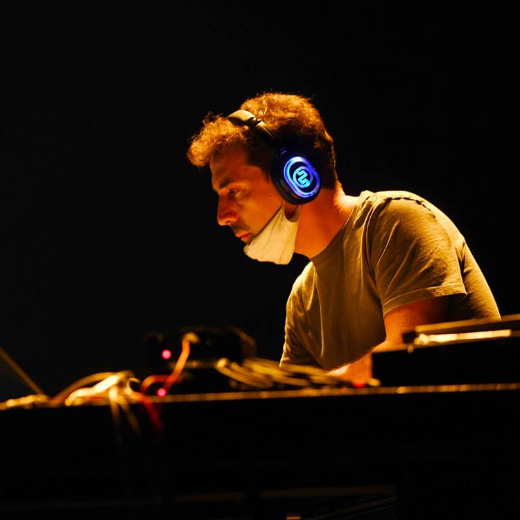 podcast-dal-vivo Musiker am Keyboard mit kabellosen Kopfhörern bei einem Live-Podcast