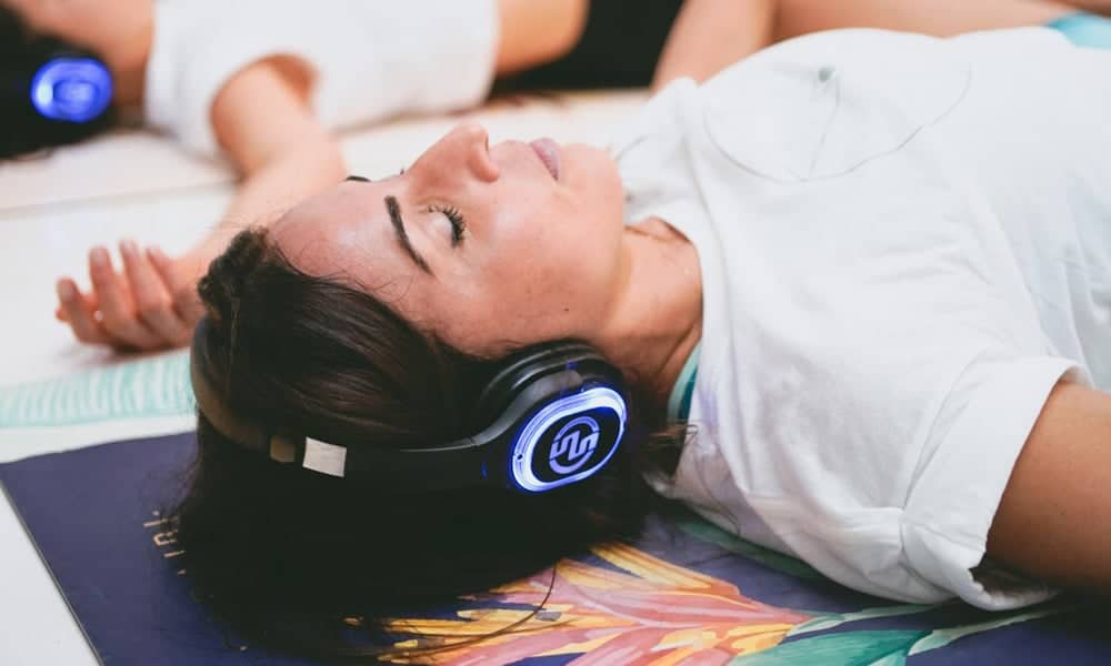 Meditazione con cuffie Liegende Frau mit kabellosen Kopfhörern während einer geführten Meditation