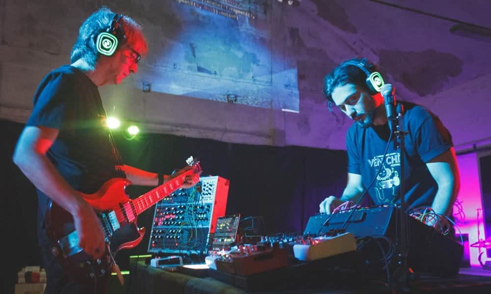 Sistemi audio modulari Musiker spielen modulare Synthesizer mit kabellosen Kopfhörern